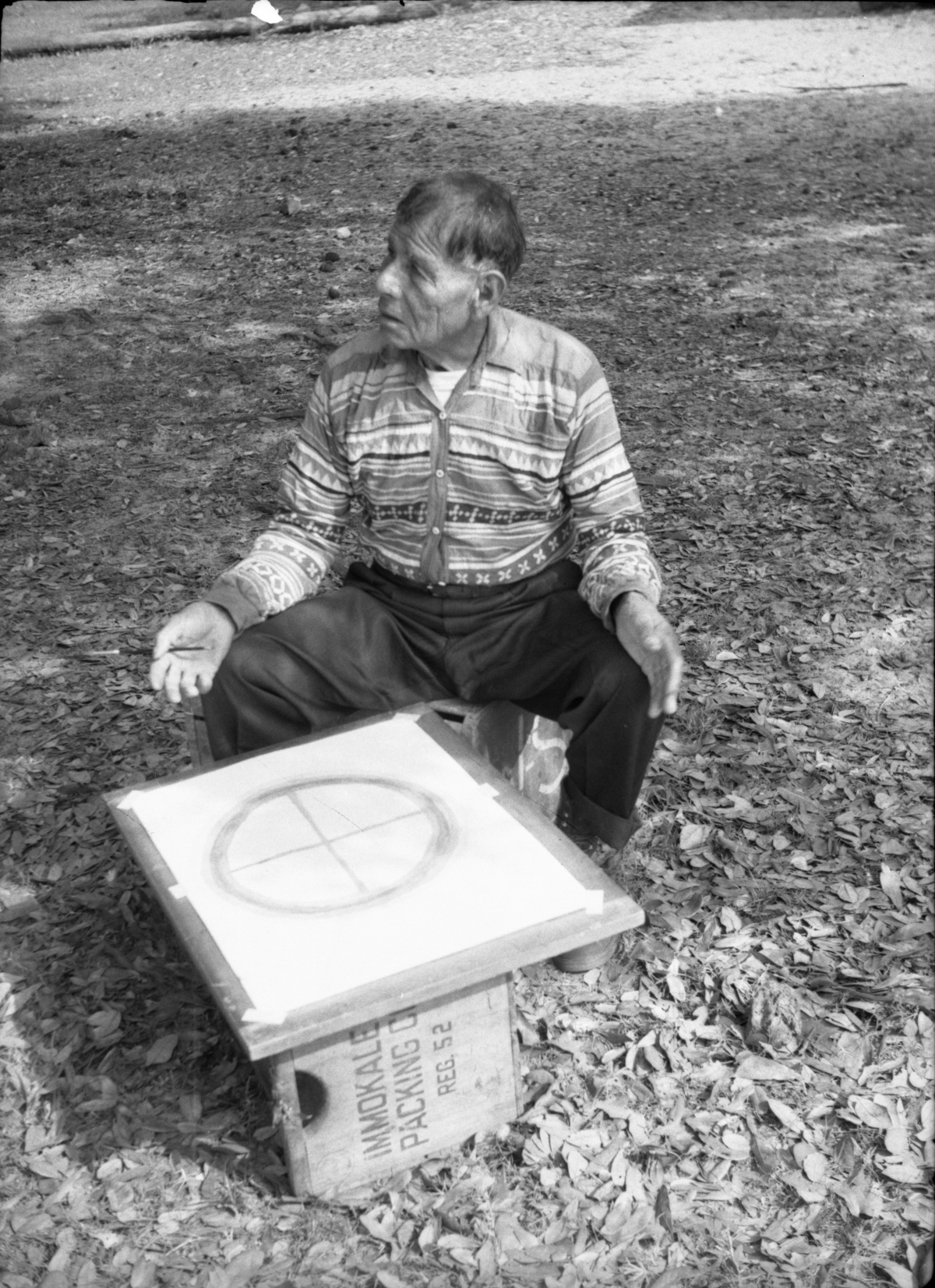 Seminole Indian Medicine Man Josie Billie sitting in chair in front of a Wheel of Life