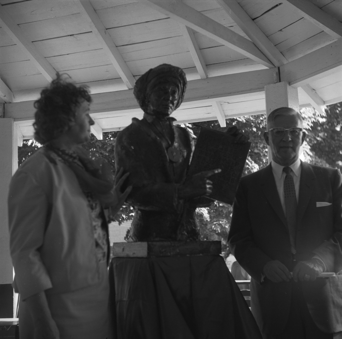 Man and woman standing by statue
