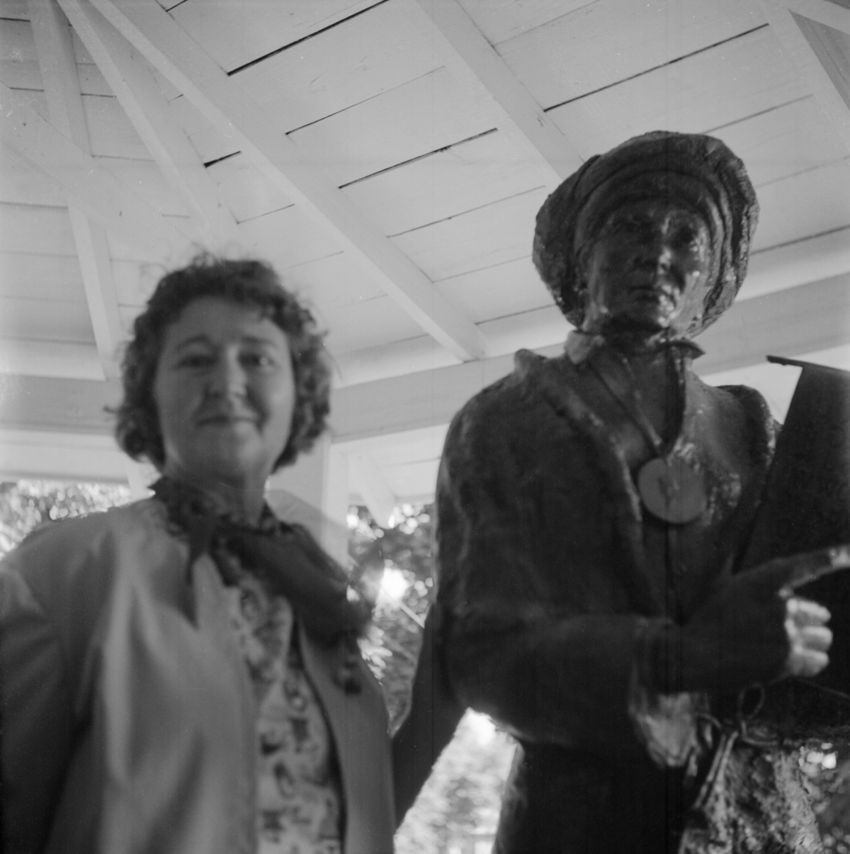 Woman standing by statue