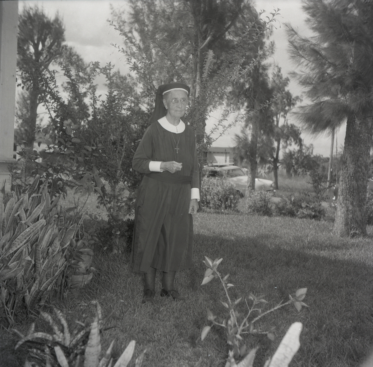 Deaconess Harriet Bedell standing in front yard of the Glade Cross Mission