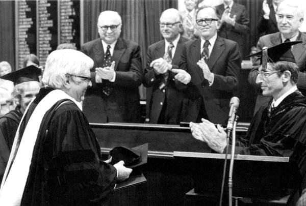 Allen Morris, dressed in academic regalia, gets a standing ovation after receiving honorary degree.