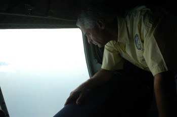 Governor Charlie Crist looking out from the U.S. Air Force turboprop airplane transporting him during Tropical Storm Fay.