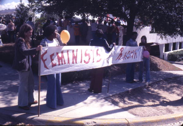 Feminists against racism holding up a banner at a KKK rally on South Monroe Street in Tallahassee, Florida.