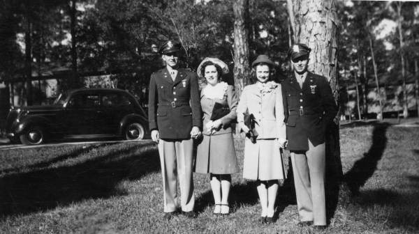 Portrait of two newly wedded couples at Dale Mabry Field near Tallahassee, Florida.