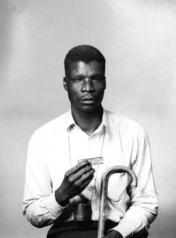 Portrait of a blind harmonica player.