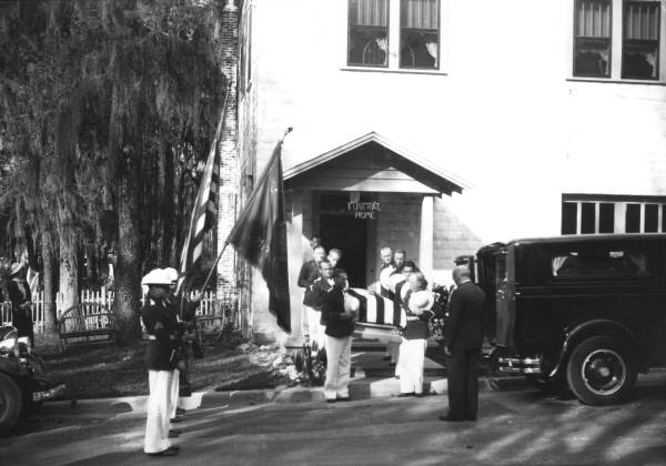 Military style funeral exiting funeral home
