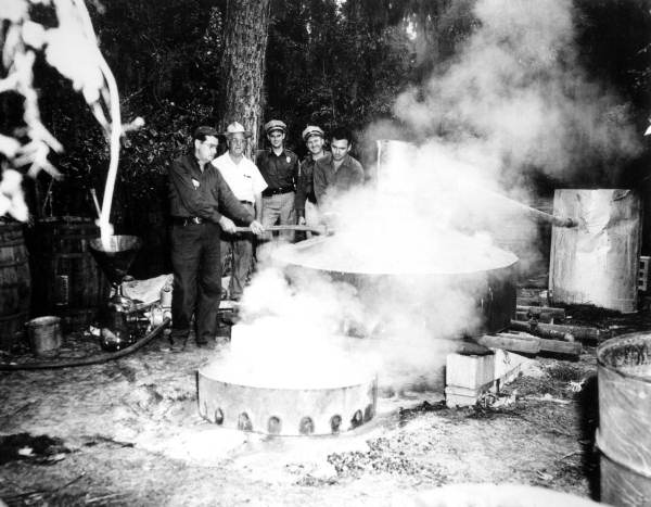 Sheriffs destroying distillery equipment.
