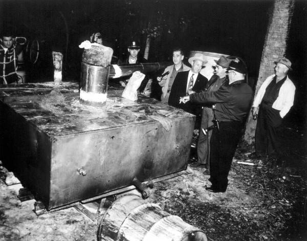 Sheriffs with distillery equipment.
