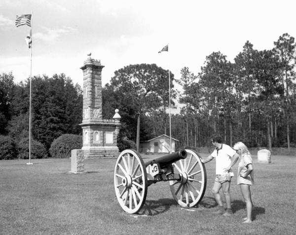 Couple looking down the barrel of a cannon, at Olustee Battlefield State Historic Site - Olustee, Florida.