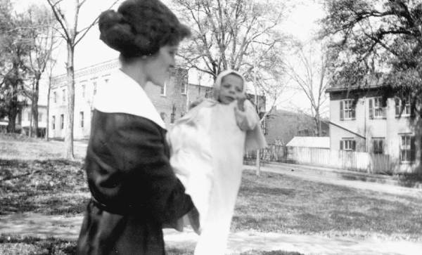 Mrs. William D. May, Senior with her son in front of Lewis State Bank.