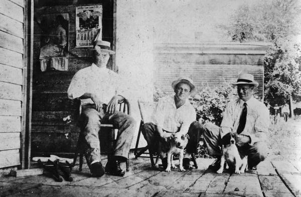 Men on porch with dogs - Tallahassee, Florida.