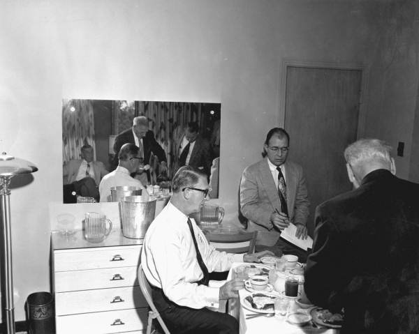 Men talking to Estes Kefauver over a meal.