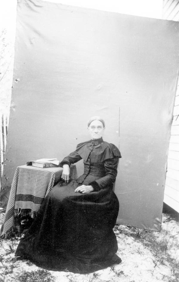 A sitting woman poses outside for a photo - Sarasota, Florida.