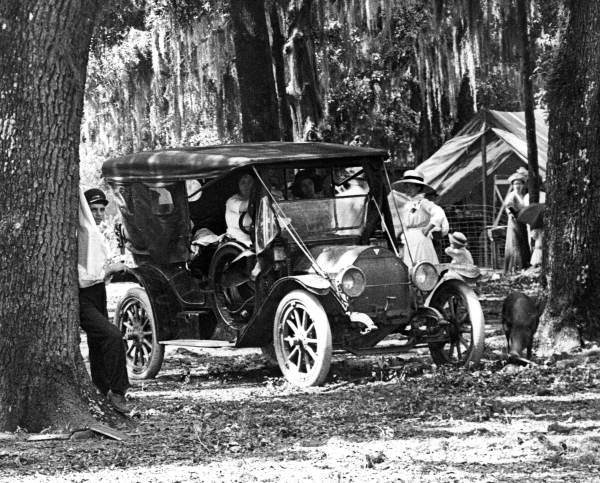 Two women sit in a car parked by a tent - Pensacola, Florida.