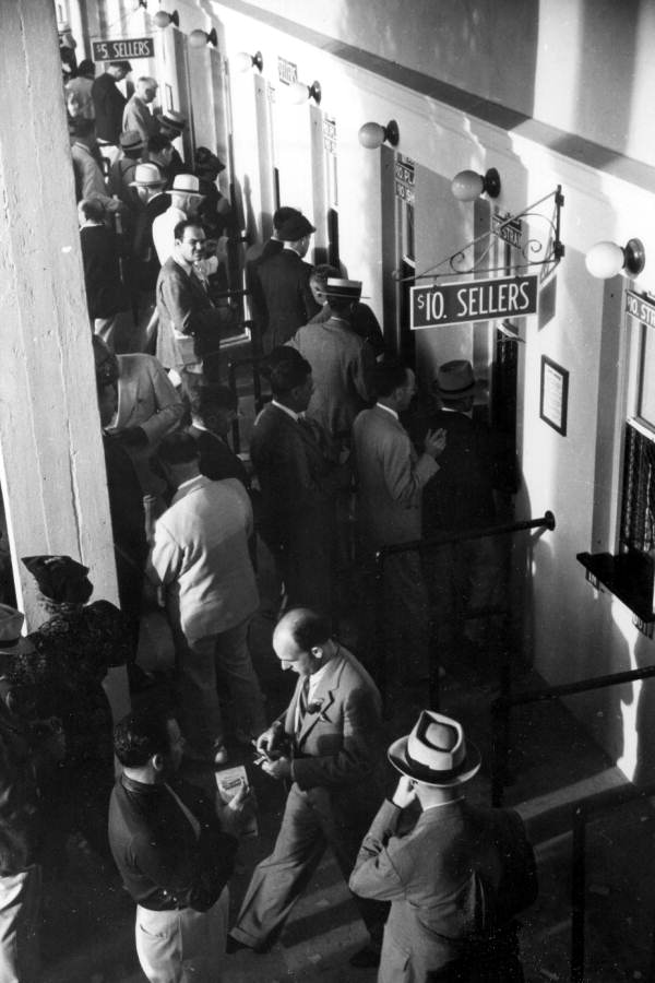 Men placing racing bets at the windows - Hialeah, Florida