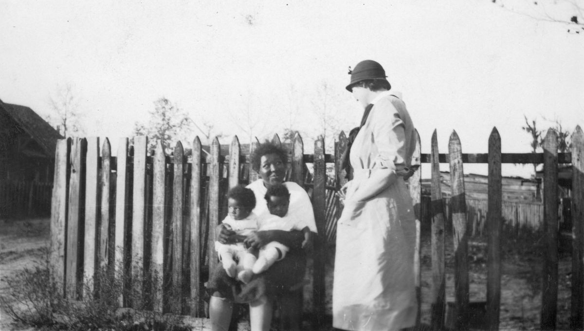 African American mother and twins being visited by a nurse from the Taylor County Health Unit.