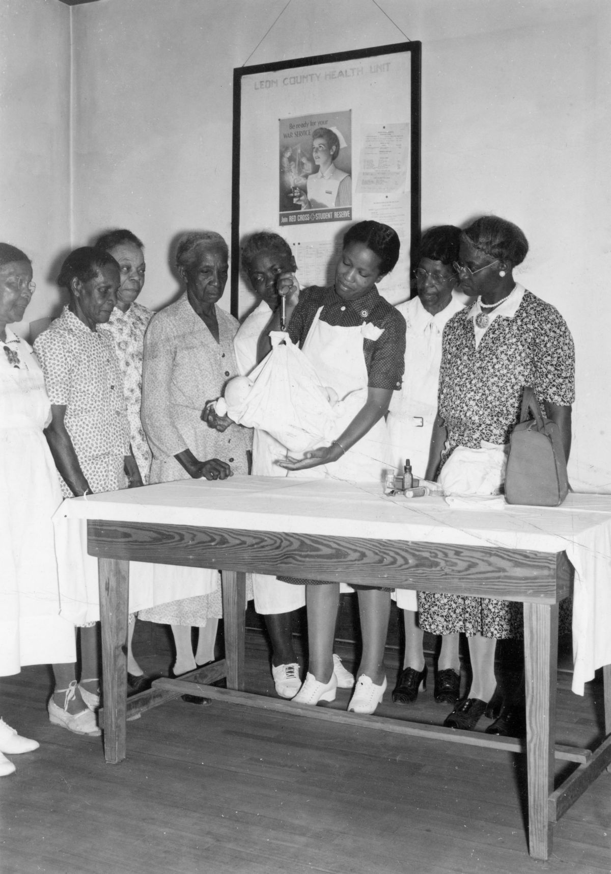 Leon County Health Dept. nurse Lillie Mae Chavis showing midwives how to use a portable scale to weigh babies.