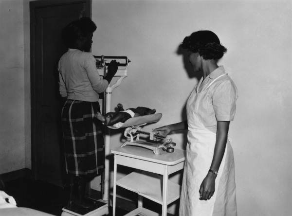 Mother and child being weighed.