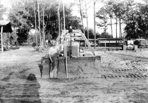 Unidentified worker measures a Caterpillar Tractor Scraper