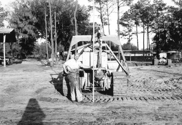 Unidentified worker measures a Caterpillar Tractor Scraper