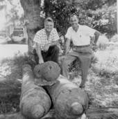 Treasure hunter Art McKee and unidentified friend posing with cannons recovered from shipwreck