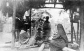 Deaconess Bedell and Seminole Indians under the cooking chickee