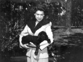 Mrs. Bill Davis wearing pelts of Karakul fur and holding a lamb at her ranch - Irvine, Florida