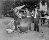 People enjoying coffee boiled in an old fashioned iron pot at a picnic - Gilchrist County, Florida
