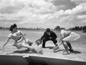 All American Girls Professional Baseball League player Marg Callaghan sliding into home plate as umpire Norris Ward watches - Opa-locka, Florida.