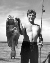Teenage boy proudly shows off a large grouper catch - Florida Keys, Florida