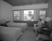Woman sitting in the bedroom at the Skyway Motel - Saint Petersburg, Florida