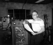 Director of Research Carl Vossberg stands by an apparatus in the laboratory of The Electron-Machine Corporation - Umatilla, Florida.