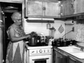 Mrs. Ada Vinton using honey to cook in her small trailer's kitchen - Fort Pierce, Florida.