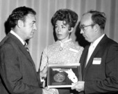 Governor Claude Kirk presenting award to Kenneth Woodburn while unidentified woman looks on - Tallahassee, Florida.