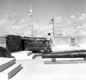 A young woman overlooking the scene from the rear of a cannon on the gundeck at the Castillo - Saint Augustine, Florida