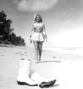 "Miss Sandy Shoes" queen Jan Arnold (later Russell) walking towards her pair of boots on the beach during the Sandy Shoes Festival in Ft. Pierce, Florida.