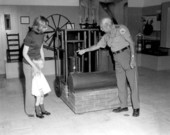 A staff member explains the ice machine to visitors at the John Gorrie Museum - Apalachicola, Florida.