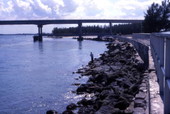 View looking toward person fishing from rocks near the bridge at Sebastian Inlet State Park - Melbourne Beach, Florida.