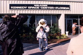 Tourist with person wearing space suit in front of the Kennedy Space Center on Merritt Island near Titusville, Florida.