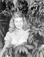 Boots Moore poses in a dress with poinsettias - Cypress Gardens, Florida
