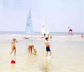 Family walking along the beach shore by catamarans - Jacksonville, Florida