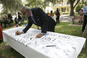 Reverend Henry Steele signing a banner during the Emancipation Day Celebration at the Knott House Museum in Tallahassee.