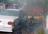 Shows fire damage to car and motorcycle parked in front of house fire at 1709 Flagler Ave..