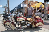 Armondo Fernandez looking over Indian motorcycle on Main St.