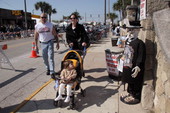 Woman pushing a toddler in stroller on Main Street during Bike Week 2006 - Daytona Beach, Florida.