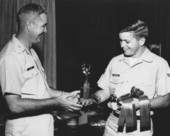 Dale McDonald receiving photo contest awards from Col. Heck.