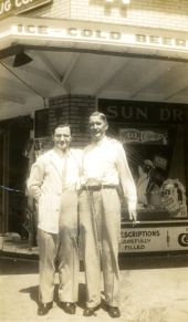 Peter Dughi and druggist in front of Sun Drug Company's store - Saint Petersburg, Florida.
