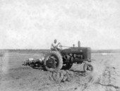 African American boy tilling field with tractor at the School for Boys in Marianna, Florida.