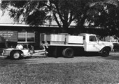 Truck and trailer in front of State Road Department .