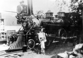 Mother and child standing by 1875 Baldwin steam engine